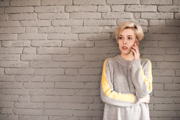 Freelancer concept with woman calling in front of wall