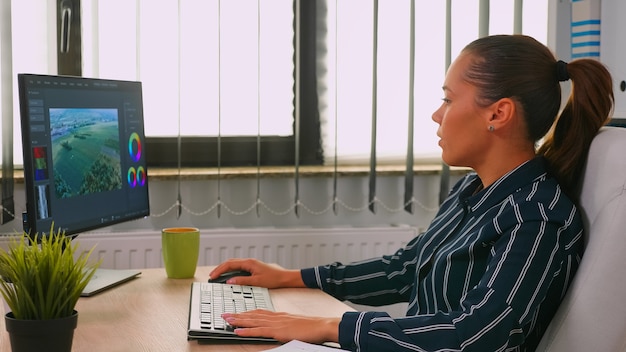 Free photo freelancer hispanic videographer editing new project working in modern company creating content. entrepreneur in professional workspace writing on computer keyboard looking at desktop