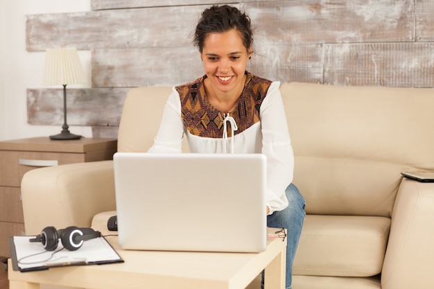 Foto gratuita donna libera professionista che sorride durante una videochiamata mentre lavora da casa.