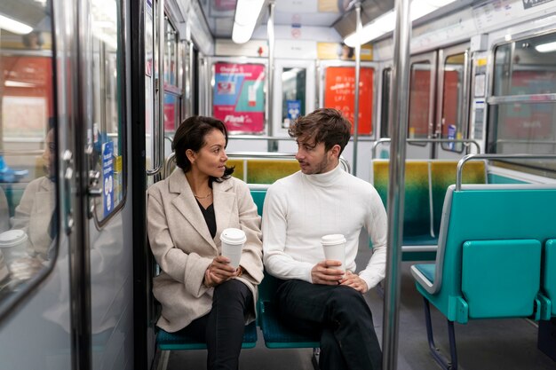 French couple riding the subway train and drinking coffee