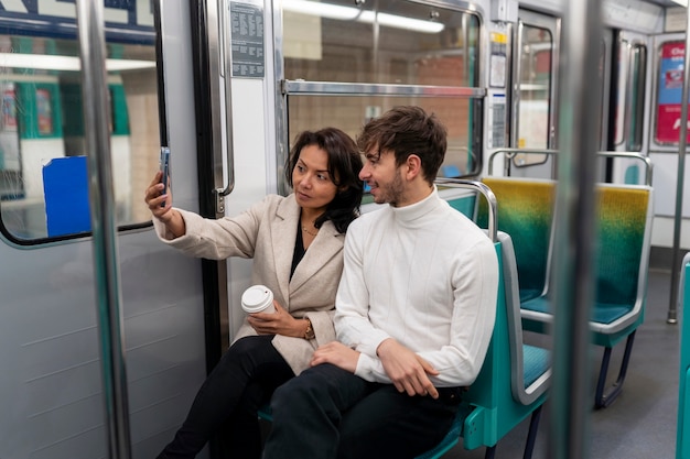 French couple riding the subway train and taking selfie