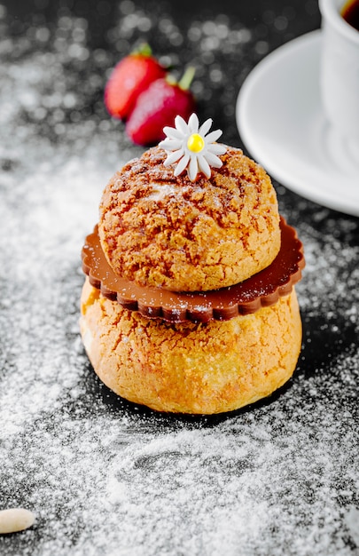 French dessert eclair with chocolate and a flower on the top.