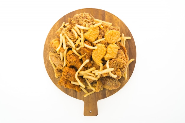 French fries and fried chicken on wooden plate