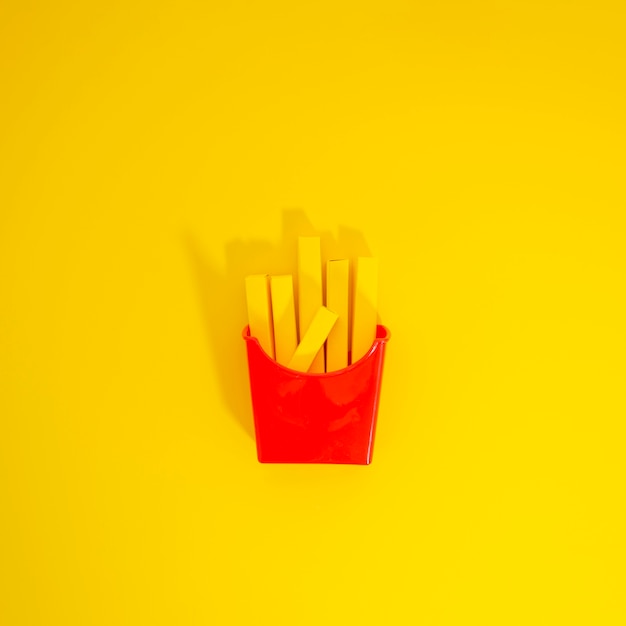 Free photo french fries replica over yellow background