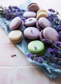French macarons with lavender flavor and fresh lavender flowers on a  tile background