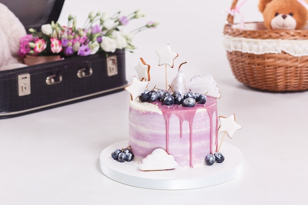 French mousse cake covered with lilac glaze on table. 
