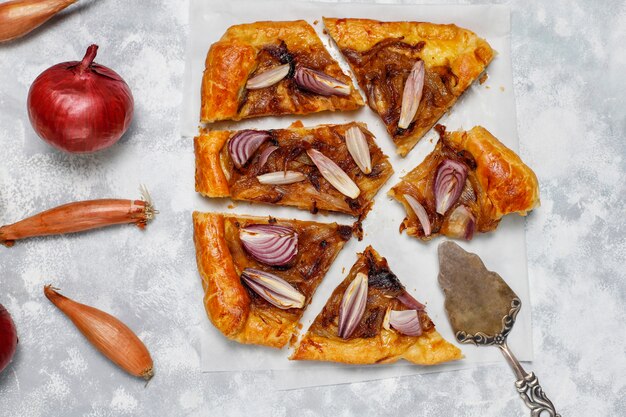 Foto gratuita galette torta di cipolle alla francese con pasta sfoglia e varie cipolle scalogno, cipolle rosse, bianche, gialle, vista dall'alto