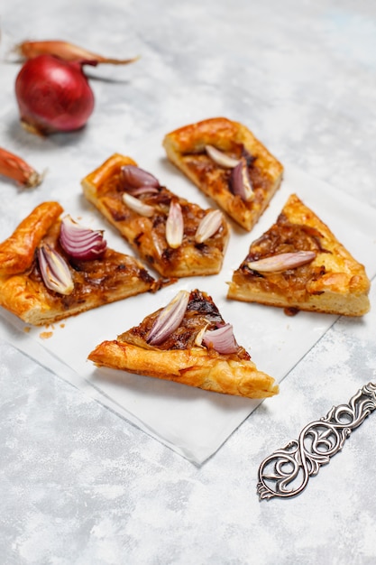 Free photo french style onion pie galette with puff pastry  and various onions shallot,red,white,yellow onions,top view