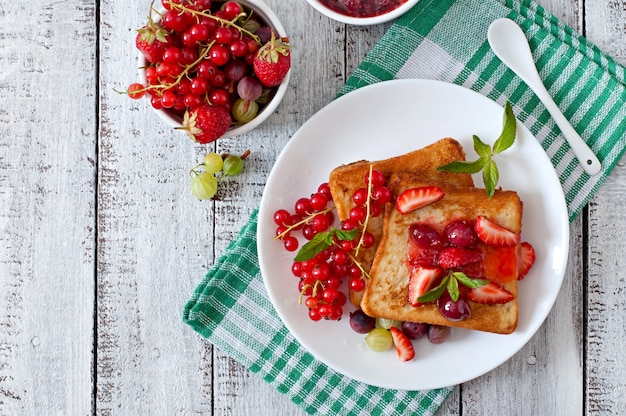 Free photo french toast with berries and jam for breakfast