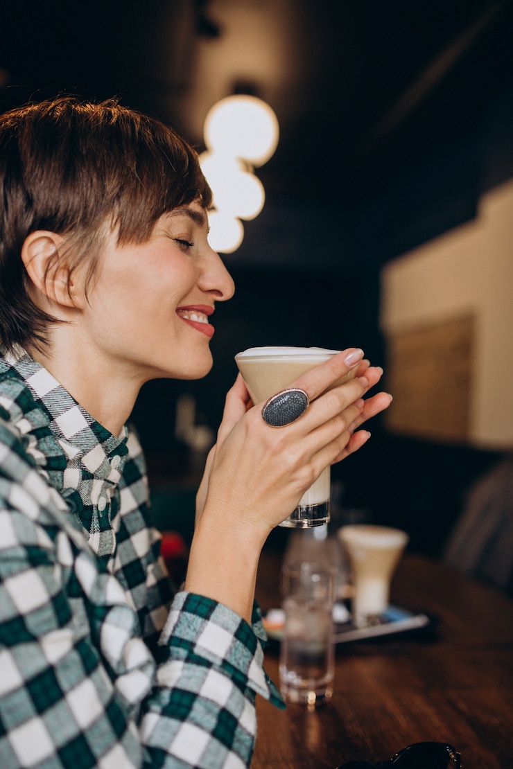 Free Photo french woman in cafe drinking latte