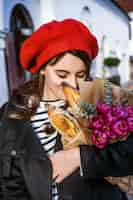 Free photo french woman with baguettes on the street in beret