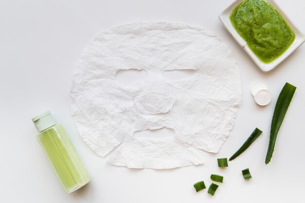 Fresh aloevera paste; spray and cream with face paper sheet on white background