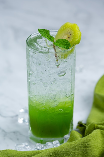 Свежевыжатый яблочный сок в стакане с зелеными яблоками.