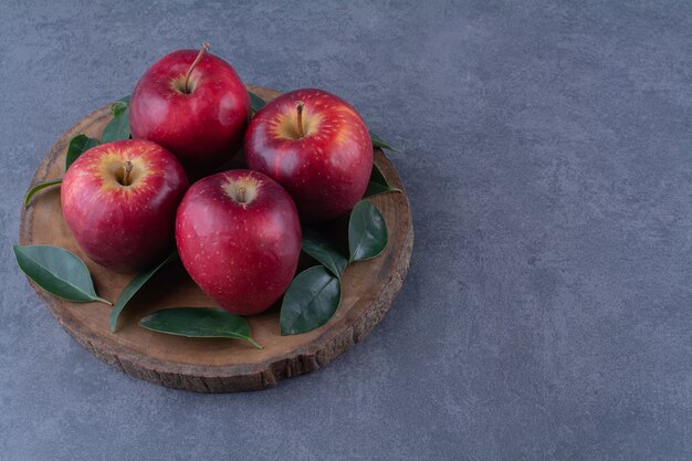 대리석 테이블에 있는 보드에 신선한 사과와 잎.