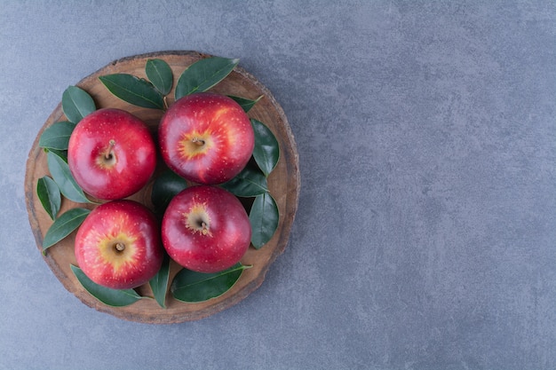 대리석 테이블에 있는 보드에 신선한 사과와 잎.