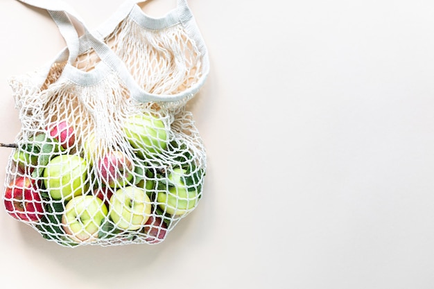 Fresh Apples in a Shopping Bag Mesh Zero waste no plastic concept A healthy diet and detox Autumn harvest Flat lay top view