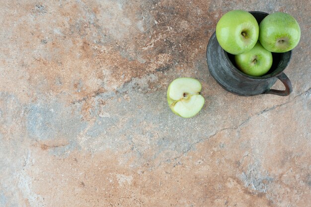 A fresh apples with an ancient cup on marble table.