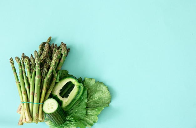 Free photo fresh asparagus plant on blue background flat lay