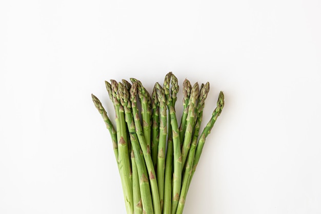 Free photo fresh asparagus plant on white background flat lay