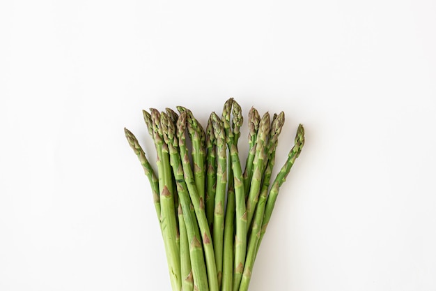 Fresh asparagus plant on white background flat lay