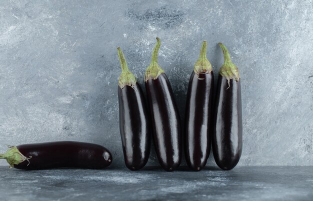 Fresh aubergine row on grey background