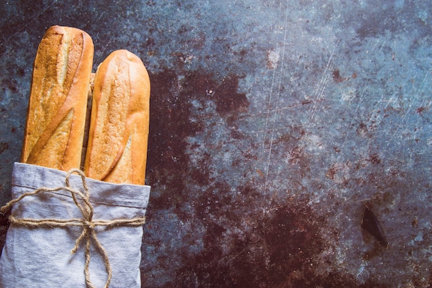 Fresh baguette on rusted table with copy space