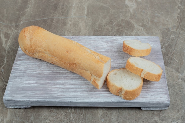 Fresh baguette slices on wooden board. High quality photo