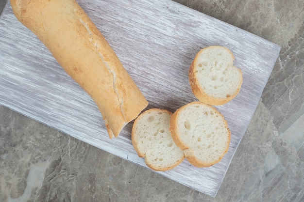 Fresh baguette slices on wooden board. High quality photo