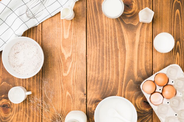 Fresh baking ingredients arrange in circular frame over wooden table