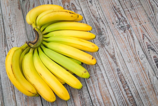 Fresh bananas on wooden table .