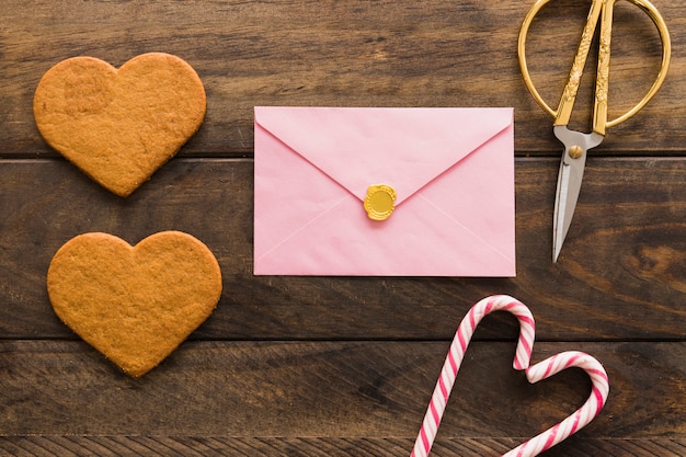 Fresh biscuits near envelope, scissors and candy canes 