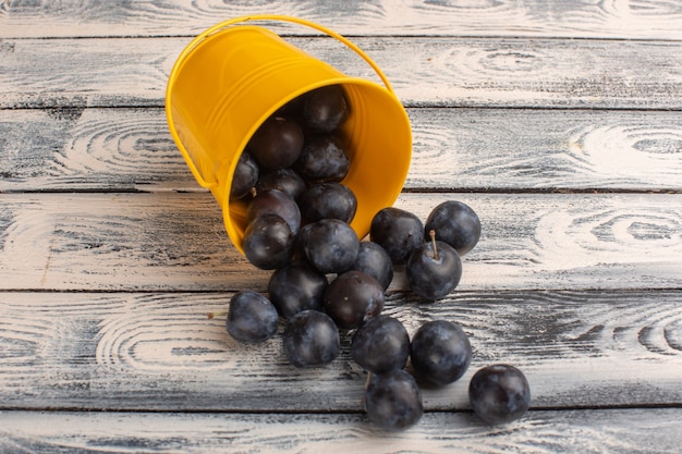 fresh blackthorns inside and outside yellow basket on grey