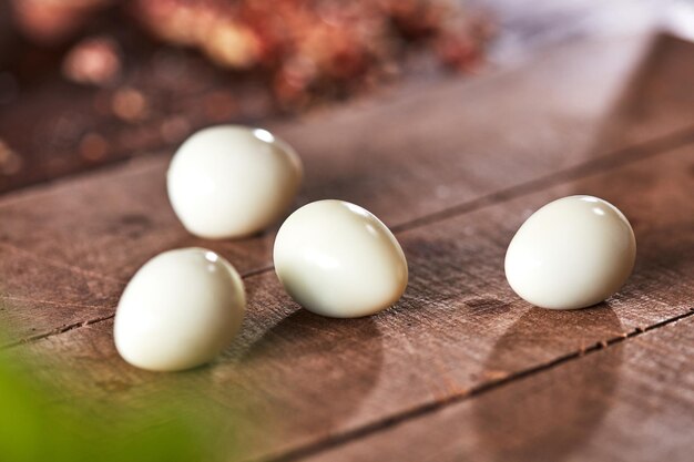 Fresh boiled peeled quail eggs on an old wooden background with reflection of shadows Healthy food