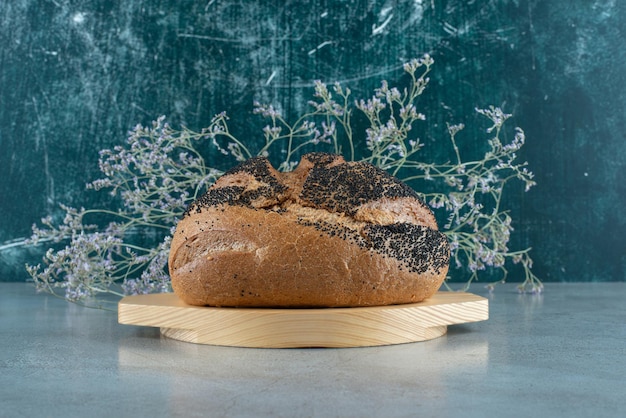 Булочка свежего хлеба на деревянной тарелке.