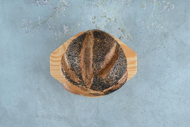 Fresh bread bun on wooden plate.