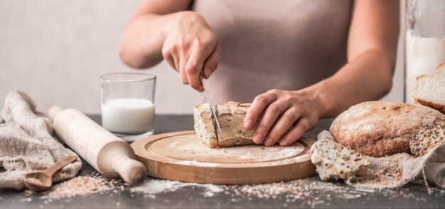 fresh bread in hands closeup on old wooden background