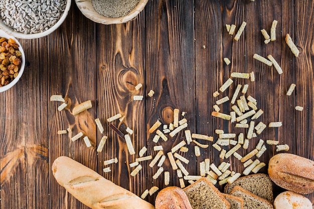 Foto gratuita pagnotta di pane fresco con ingredienti sul tavolo di legno