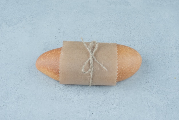 Free photo fresh bread roll tied with rope on stone surface