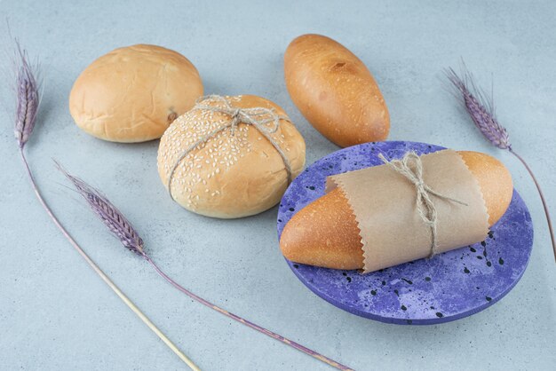 Fresh bread rolls and buns on stone surface