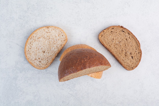 Fresh bread slices on stone surface