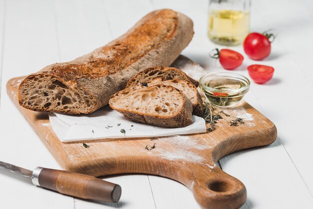 Свежий хлеб с ножом на разделочной доске