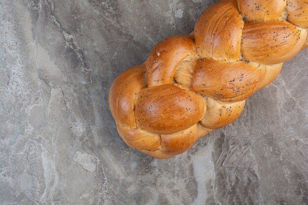 Fresh bread with poppy seeds on marble background