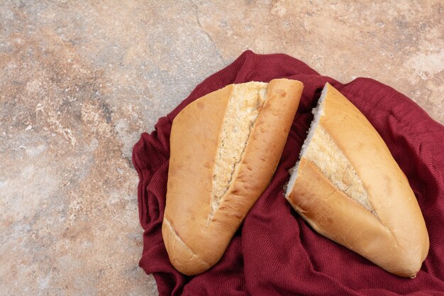 Свежий хлеб с красной скатертью на мраморном фоне