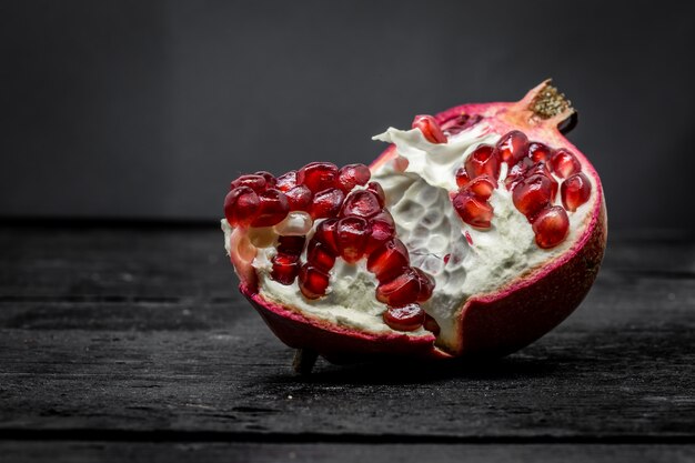 Fresh broken pomegranate on black, macro