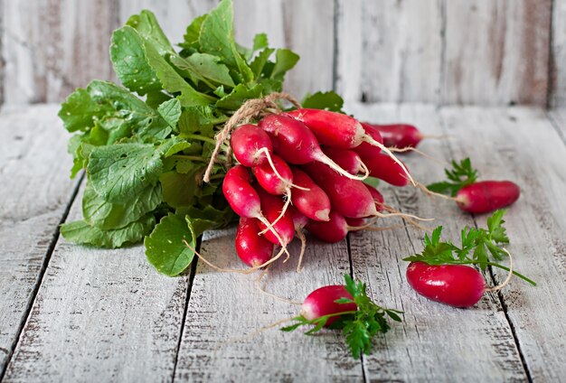 Fresh bunch of radishes on old wooden background