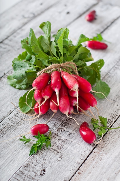 Fresh bunch of radishes on old wooden background