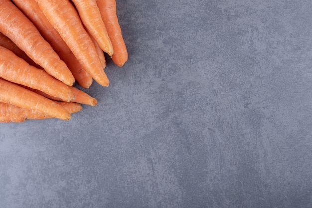 Fresh carrot bunch, on the marble background.