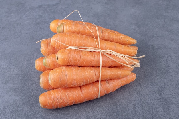 Foto gratuita mazzo di carote fresche, sulla superficie di marmo.