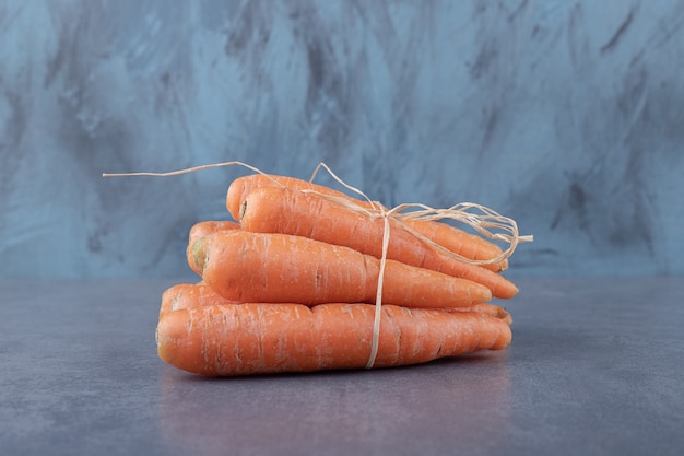 Free photo fresh carrot bunch, on the marble surface.