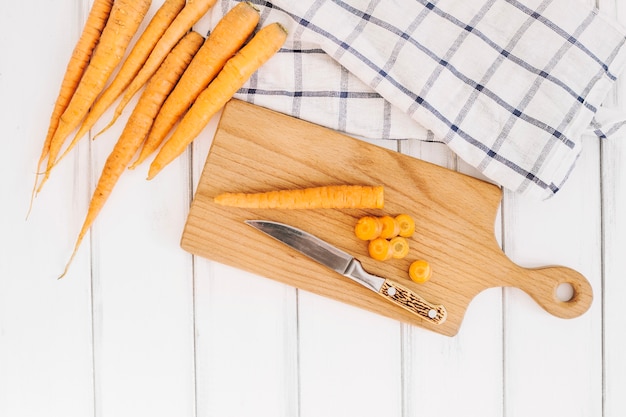 Foto gratuita carota e coltello freschi a bordo